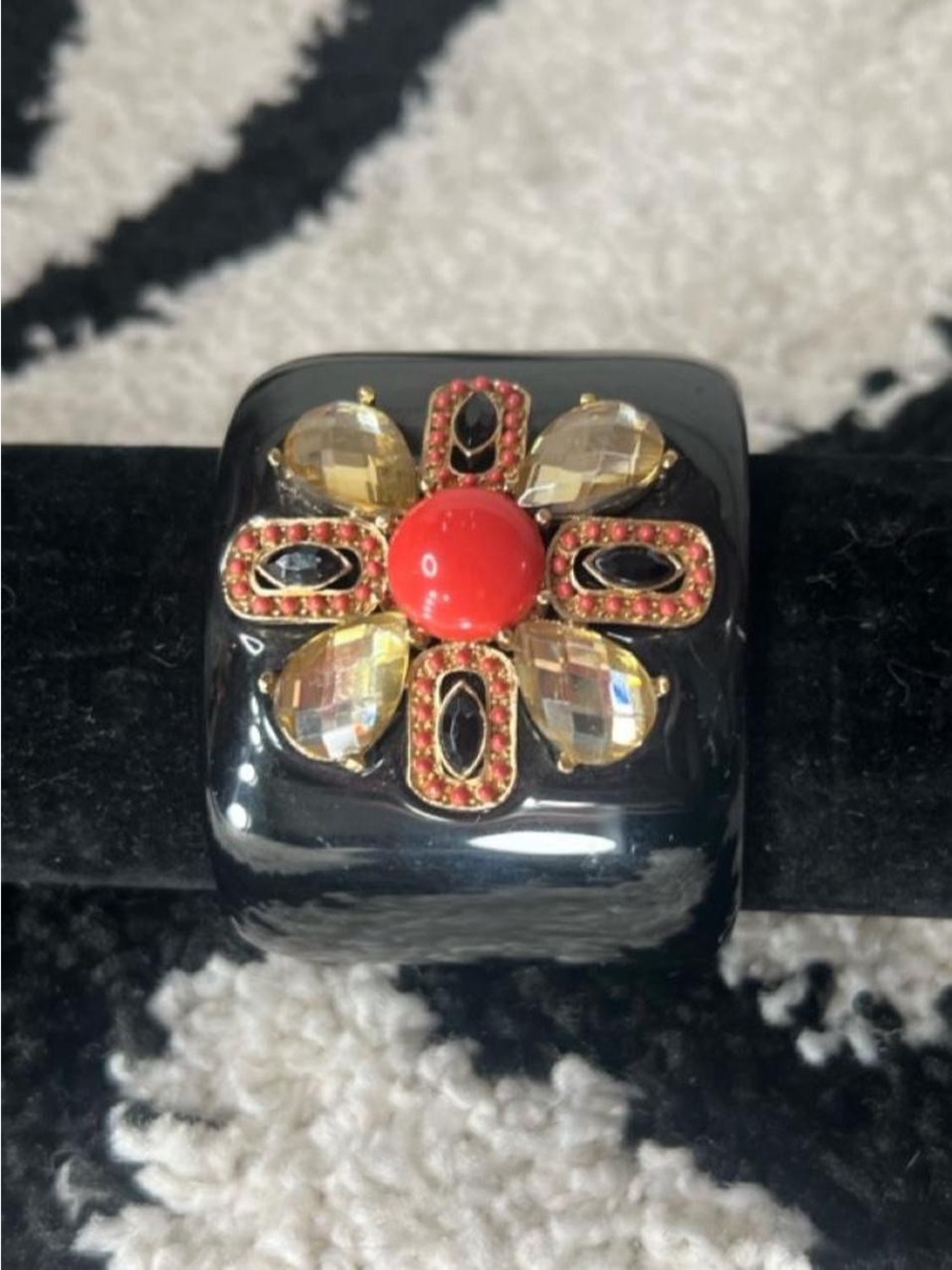Black clamp bangle with orange yellow and gold tone flower design